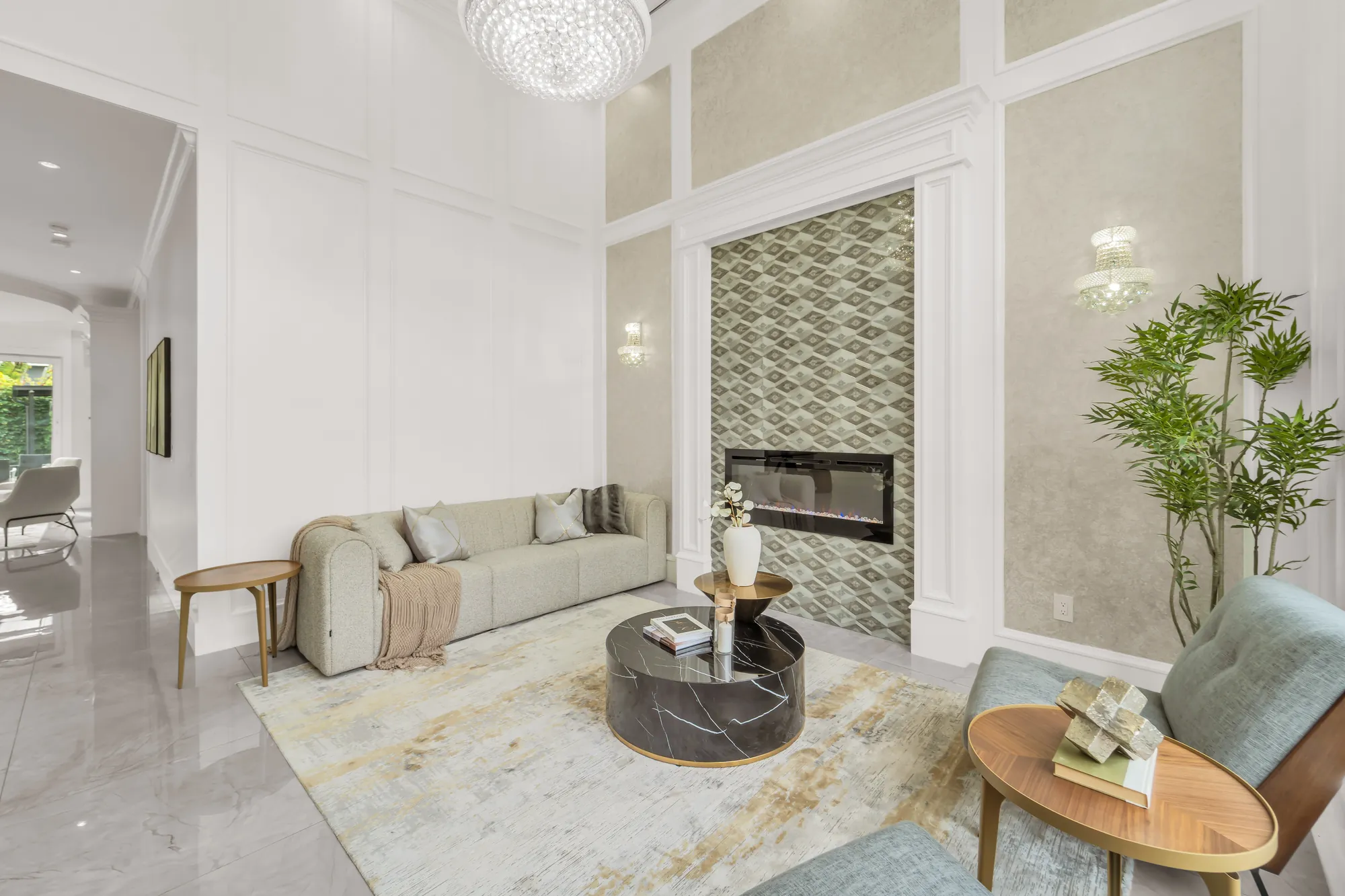 The living room toward its fireplace: the tiled surround rising the full height of the room, a sofa and a lounge chair, a doorway to the hall at the left
